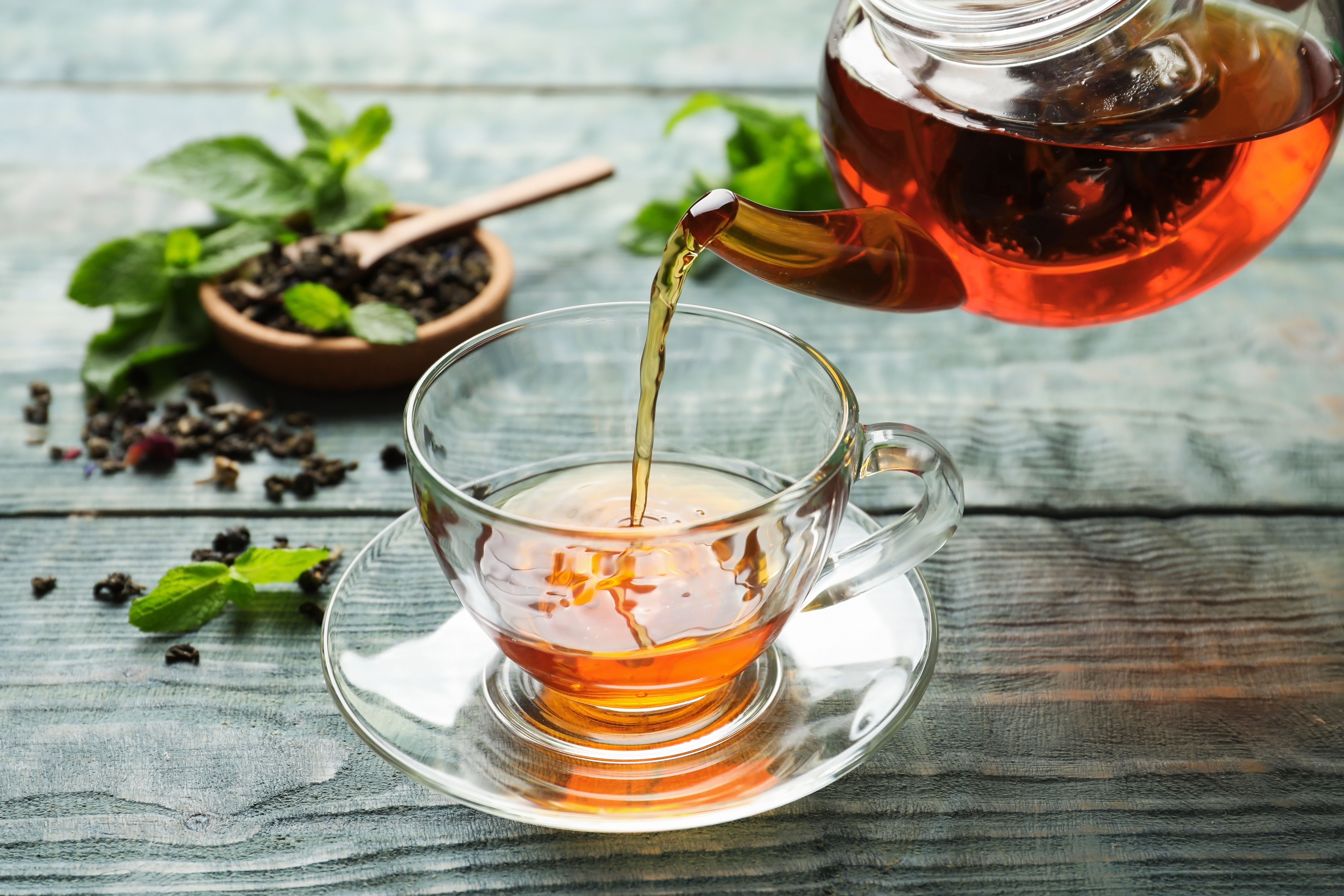 Photograph of the Nothin But a Good Chai menu item being poured into a glass tea cup.